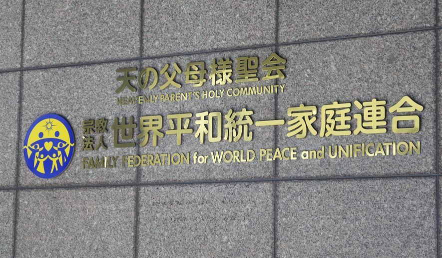 The logo of of Family Federation for World Peace and Unification, formerly known as Unification Church, is seen on the wall of the the building housing its headquarters in Tokyo, Thursday, Oct. 12, 2023. Japan’s government is convening a meeting of religious affairs council Thursday to ask experts to decide whether to seek a court order to revoke legal status from the Unification Church, whose devious fundraising tactics and cozy ties with the governing party have triggered public outrage. (Kyodo News via AP)