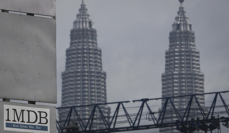 FILE - In this Wednesday, July 8, 2015 photo, a 1MDB (1 Malaysia Development Berhad) logo is set against the Petronas Twin Towers at the flagship development site, Tun Razak Exchange in Kuala Lumpur, Malaysia. The Malaysian government questioned Thursday, Oct. 12, 2023, a move by Goldman Sachs to file for arbitration in a dispute over a settlement of a case involving the multibillion-dollar looting of a sovereign wealth fund. (AP Photo/Joshua Paul, File)