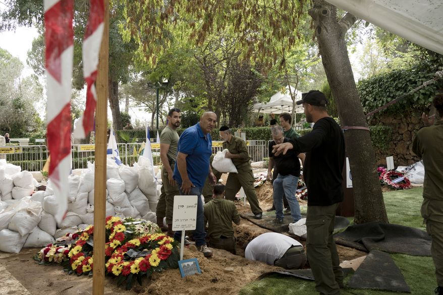 At Mt. Herzl military cemetery, grave diggers set up between funerals for Israeli soldiers killed in Saturday's surprise attack by Hamas militants on the Gaza border, in Jerusalem, Tuesday, Oct. 10, 2023. (AP Photo/Maya Alleruzzo)