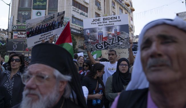 Palestinian demonstrators carry banners and chant anti Israel slogans during a rally in support of the Gaza Strip, in the West Bank city of Ramallah, Friday, Oct. 13, 2023. Tens of thousands of Muslims demonstrated Friday across the Middle East in support of the Palestinians and against the intensifying Israeli bombardment of Gaza, underscoring the risk of a wider regional conflict as Israel prepares for a possible ground invasion. (AP Photo/Nasser Nasser)
