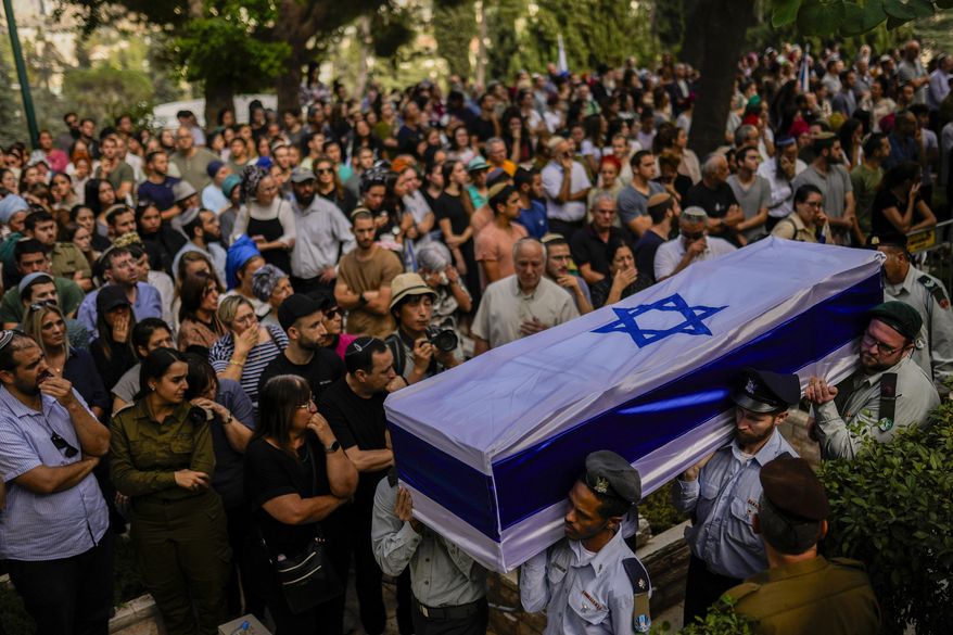 Israeli soldiers carry the flag-covered coffin of Shilo Rauchberger at the Mount Herzl cemetery in Jerusalem, Thursday, Oct. 12, 2023. In Israel on Saturday, rabbis worked around the clock at Shura military base in Israel to identify and count the dead civilians and soldiers gunned down in the Hamas attack last week. Israel's military rabbinate is working on Shabbat for the first time since 2005. Some of the bodies have been brought to Mount Herzl, Israel's national cemetery in Jerusalem. (AP Photo/Francisco Seco, File)