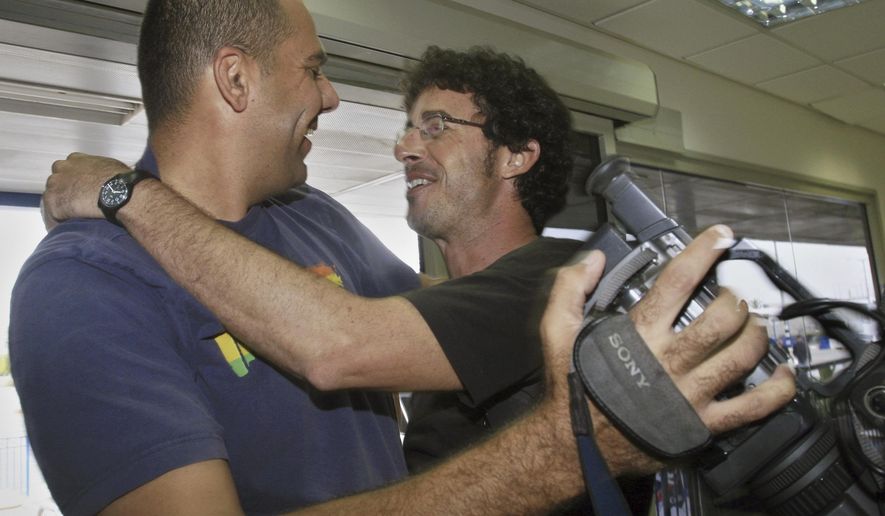 FILE - Associated Press photographer Emilio Morenatti, right, embraces video journalist Yaniv Zohar as he arrives to Israel from the Gaza Strip at the Erez border crossing Oct. 25, 2006, after Morenatti was released from Palestinian gunmen who abducted him at gunpoint in Gaza. Zohar, a former Associated Press video journalist who covered conflicts and major news in his native country for three decades, was killed in his home during Hamas' bloody cross-border rampage on Oct. 7, 2023, with his wife and two daughters. He was 54. (AP Photo/Tsafrir Abayov, File)