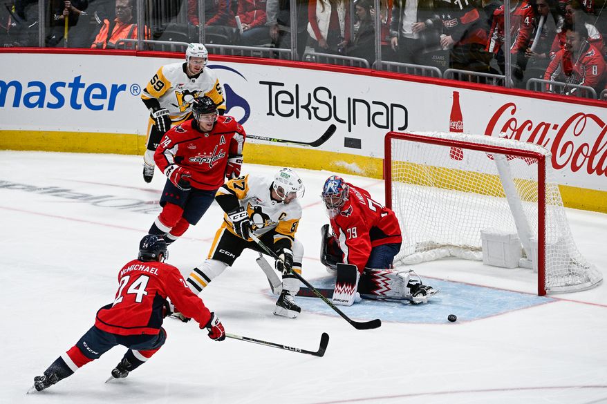 Pittsburgh Penguins center Sidney Crosby (87) chases after a loose puck in front of Washington Capitals goalie Charlie Lindgren (79) at Capital One Arena, Washington, D.C., October 13, 2023. (Photo by Brian Murphy for the Washington Times)