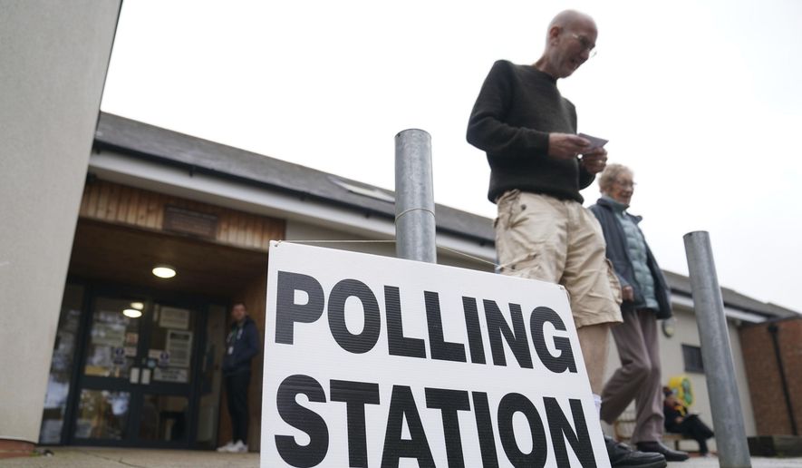 People exit the Shefford Town Memorial Association after casting their vote in the Mid Bedfordshire by-election, in Shefford, England, Thursday, Oct. 19, 2023. Voters are casting ballots Thursday in two special elections in England that could add more misery to the beleaguered governing Conservative Party. The Conservatives won both Tamworth in central England and Mid-Bedfordshire, north of London, by large margins during the last national election, in 2019. But both constituencies’ lawmakers resigned under a cloud. (Joe Giddens/PA via AP)