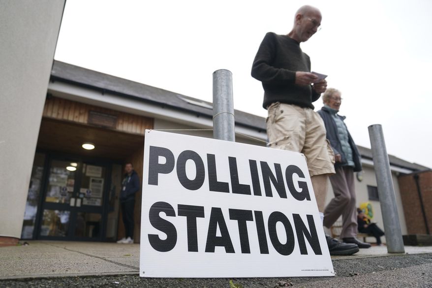 People exit the Shefford Town Memorial Association after casting their vote in the Mid Bedfordshire by-election, in Shefford, England, Thursday, Oct. 19, 2023. Voters are casting ballots Thursday in two special elections in England that could add more misery to the beleaguered governing Conservative Party. The Conservatives won both Tamworth in central England and Mid-Bedfordshire, north of London, by large margins during the last national election, in 2019. But both constituencies’ lawmakers resigned under a cloud. (Joe Giddens/PA via AP)