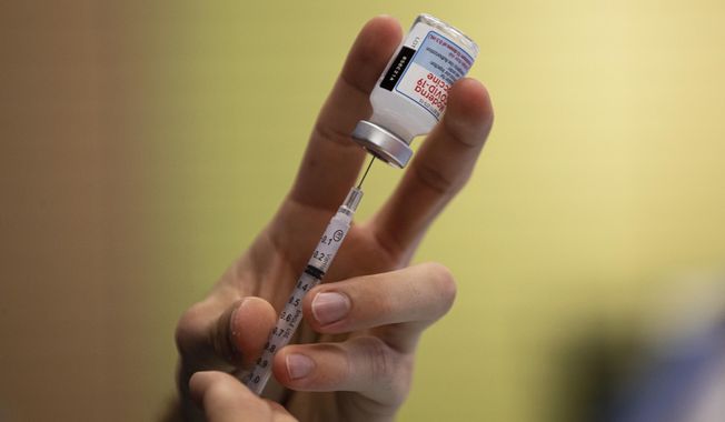 A dose of a Moderna COVID-19 vaccine is prepared, Thursday, Nov. 4, 2021, in Barboursville, W.Va. A federal grand jury has indicted Timothy Priddy, a West Virginia state health office manager, on charges that he approved more than $34 million in coronavirus pandemic relief payments to a private firm without verifying that the vendor provided goods and services it was under contract to deliver. (Sholten Singer/The Herald-Dispatch via AP)