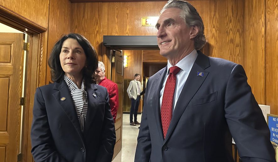 North Dakota Republican Gov. Doug Burgum, at right, and Lt. Gov. Tammy Miller, at left, stand in the state House of Representatives on Monday, Oct. 23, 2023, in the state Capitol in Bismarck, N.D., before Burgum addressed the Legislature. Lawmakers were back in Bismarck to begin a special session to primarily address a major budget bill voided last month by the state Supreme Court. (AP Photo/Jack Dura)