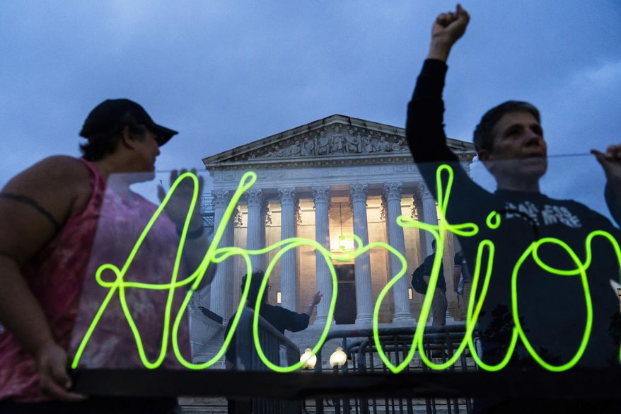 FILE - Activists mark the first anniversary of the Supreme Court's decision in Dobbs v. Jackson Women's Health Organization, by displaying neon signage in support of abortion access in front of the Supreme Court on June 23, 2023, in Washington. A new survey finds that the total number of abortions provided in the U.S. after bans started going into effect in some states last year increased slightly. The report sponsored by the Society of Family Planning found that the numbers fell to nearly zero in states with bans on abortion at all stages of pregnancy after a U.S. Supreme Court ruling in 2022 cleared the way for the restrictions. (AP Photo/Nathan Howard, File)