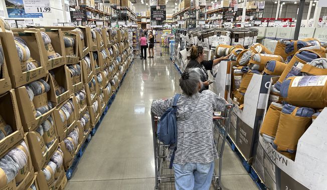 Shoppers look over blankets on sale in a Costco warehouse on Aug. 24, 2023, in Sheridan, Colo. On Thursday, the Commerce Department issued its first of three estimates of how the U.S. economy performed in the third quarter of 2023. (AP Photo/David Zalubowski, File)