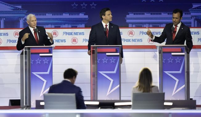 Florida Gov. Ron DeSantis listens as former Vice President Mike Pence and businessman Vivek Ramaswamy speak during a Republican presidential primary debate hosted by FOX News Channel Wednesday, Aug. 23, 2023, in Milwaukee. In the foreground are moderators Brett Baier and Martha MacCallum. (AP Photo/Morry Gash, File)