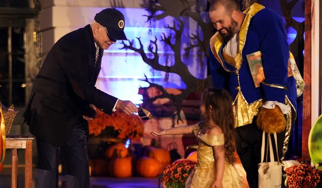 President Joe Biden gives treats to trick-or-treaters on the South Lawn of the White House, on Halloween, Monday, Oct. 30, 2023. (AP Photo/Andrew Harnik)
