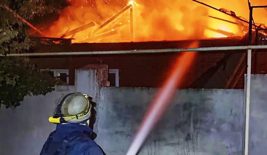In this photo provided by the Ukrainian Emergency Service, emergency services personnel work to extinguish a fire in Kherson, Ukraine, on Monday, Oct. 30, 2023, following Russian shelling attacks. Russian shells struck residential areas of Ukraine's southern Kherson region, killing a 91-year-old woman in what a local official described Monday as a "terrifying night" in the 20-month war that shows no signs of ending. The overnight shelling set fire to a high-rise apartment building, blew out windows and reduced some apartments to rubble, according to video footage posted by Kherson Gov. Oleksandr Prokudin. (Ukrainian Emergency Service via AP)