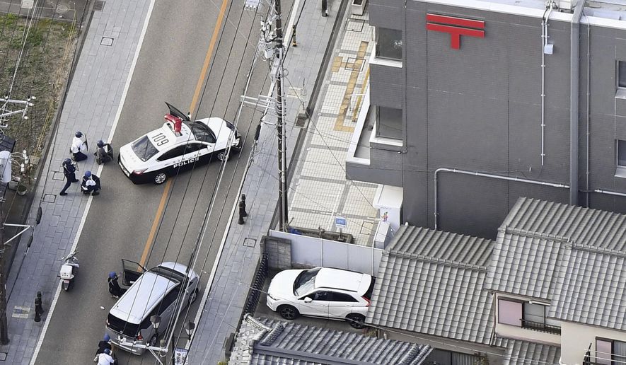 This aerial photo shows first responders take position outside the post office where a man is believed to hole up in Warabi city, Saitama prefecture, north of Tokyo, Tuesday, Oct. 31, 2023. (Kyodo News via AP)