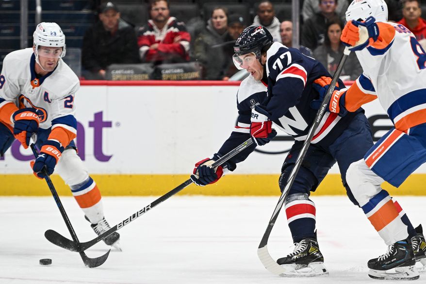 Washington Capitals right wing T.J. Oshie (77) reaching for the puck during the first period of an NHL game against the New York Islanders at Capital One Arena in Washington D.C., November 2, 2023. (Photo by Billy Sabatini)