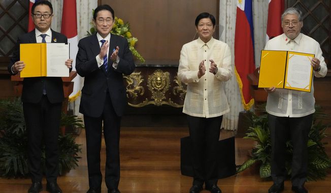 Philippine President Ferdinand Marcos Jr.,second from right, and Japanese Prime Minister Fumio Kishida second from left, applaud after the exchange of documents at the Malacanang presidential palace in Manila, Philippines on Friday, Nov. 3, 2023. Kishida is expected to announce a new security aid package to the Philippines and the start of negotiations for a defense pact in a high-profile visit to Manila as Tokyo boosts alliances to counter China&#x27;s growing assertiveness. Also in photo holding documents are Japan Ambassador Kazuhiko Koshikawa, left, and Philippines Foreign Affairs Secretary Enrique Manalo, right,. (AP Photo/Aaron Favila,Pool)