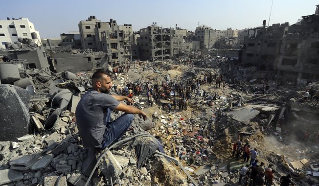 A man sits on the rubble overlooking the debris of buildings that were targeted by Israeli airstrikes in the Jabaliya refugee camp, northern Gaza Strip, Nov. 1, 2023. The White House says Israel has agreed to put in place four-hour daily humanitarian pauses in its assault on Hamas in northern Gaza. (AP Photo/Abed Khaled) **FILE**