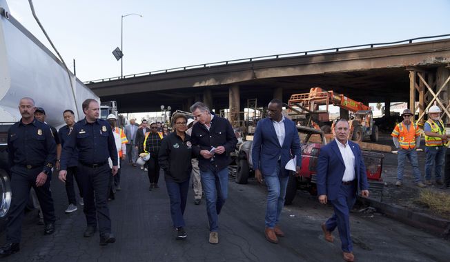 California Gov. Gavin Newsom, center right, and Los Angeles Mayor Karen Bass, center left, tour the site of a fire that erupted Saturday under Interstate 10, in Los Angeles, Monday, Nov. 13, 2023. (Eric Thayer/Los Angeles Times via AP)