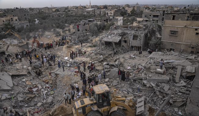 Palestinians look for survivors following an Israeli airstrike in Khan Younis, southern Gaza Strip, Sunday, Nov. 12, 2023. (AP Photo/Fatima Shbair)