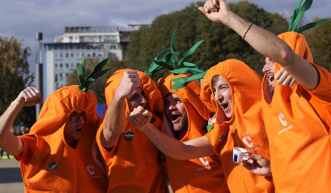 Jannik Sinner&#x27;s supporters called &quot;Carota Boys&quot; cheer outside the Pala Alpitour before the singles tennis match between Italy&#x27;s Jannik Sinner and Greece&#x27;s Stefanos Tsitsipas, of the ATP World Tour Finals at the Pala Alpitour, in Turin, Italy, Sunday, Nov. 12, 2023. They鈥檝e quickly become some of the most recognizable fans in tennis. And what began as a spur-of-the-moment idea between six fans of Jannik Sinner dressed as carrots has turned into a fully sponsored globe-trotting enterprise. After first appearing at the Italian Open in May, the orange-clad 鈥淐arota Boys鈥� quickly picked up support from up support from an Italian coffee brand and were sent to support Sinner at the French Open, Wimbledon and the U.S. Open. (AP Photo/Antonio Calanni)