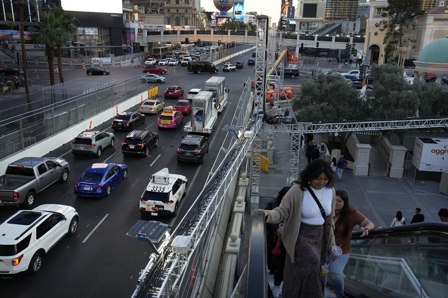 Pedestrians take an escalator along the Las Vegas Strip beside rigging and fencing installed ahead of the Las Vegas Formula One Grand Prix auto race Friday, Nov. 10, 2023, in Las Vegas. (AP Photo/John Locher) **FILE**