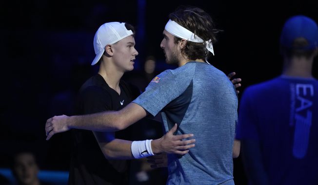 Greece&#x27;s Stefanos Tsitsipas, right, embraces Denmark&#x27;s Holger Rune after injuring during the singles tennis match of the ATP World Tour Finals at the Pala Alpitour, in Turin, Italy, Tuesday, Nov. 14, 2023. (AP Photo/Antonio Calanni)