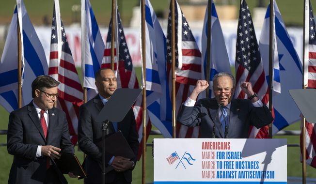 Senate Majority Leader Chuck Schumer of N.Y., right, speaks as Speaker of the House Mike Johnson of La., left, and House Minority Leader Hakeem Jeffries of N.Y., listen at the March for Israel on Tuesday, Nov. 14, 2023, on the National Mall in Washington. (AP Photo/Mark Schiefelbein)