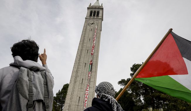 A banner calling for a cease-fire hangs from UC Berkeley&#x27;s Sather Tower as hundreds of people, mostly students, gather to call for a cease fire in Gaza and read the names of Palestinians killed, during a protest on the UC Berkeley campus in Berkeley, Calif. on Thursday, Nov. 16, 2023. (Bront毛 Wittpenn/San Francisco Chronicle via AP)