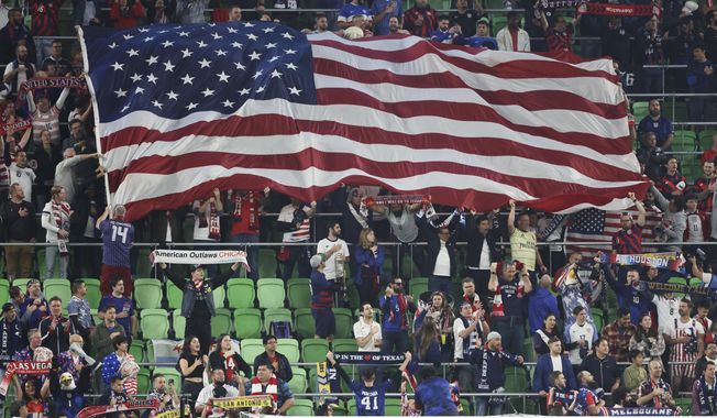 Fans wave a U.S. flag at the start of the first leg of a CONCACAF Nations League soccer quarterfinal between the United States and Trinidad and Tobago on Thursday, Nov. 16, 2023, in Austin, Texas. (AP Photo/Stephen Spillman)