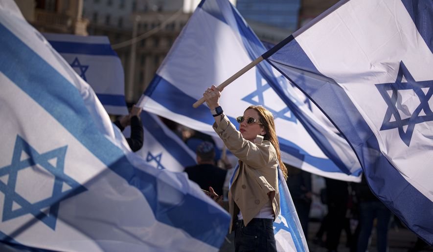 FILE - A woman holds an Israeli flag during a rally in solidarity with Israel and those held hostage by Hamas in Gaza in Bucharest, Romania on Nov. 12, 2023. (AP Photo/Andreea Alexandru, File)