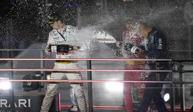 Red Bull driver Max Verstappen, of the Netherlands, left, and Ferrari driver Charles Leclerc, of Monaco, celebrate after a first and second place finish during the Formula 1 Las Vegas Grand Prix auto race, Sunday, Nov. 19, 2023, in Las Vegas. (AP Photo/John Locher)