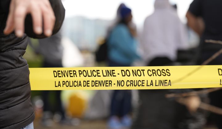 Police tape is put up during a city-sponsored sweep of an encampment overlooking the city skyline on Diamond Hill Wednesday, Nov. 1, 2023, in Denver. The sweep was just one of several staged in various locations across the Mile High City. (AP Photo/David Zalubowski)