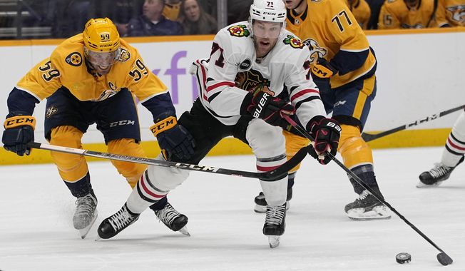 Chicago Blackhawks left wing Taylor Hall, right, moves the puck past Nashville Predators defenseman Roman Josi (59) during the first period of an NHL hockey game Saturday, Nov. 18, 2023, in Nashville, Tenn. (AP Photo/George Walker IV)