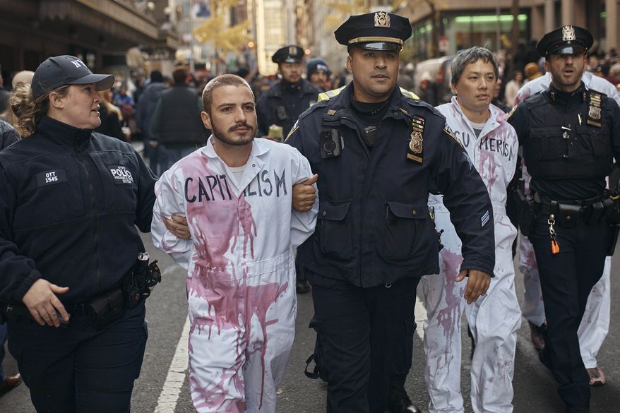 Pro-Palestinians protestors get arrested by the police during the Macy's Thanksgiving Day Parade on Thursday, Nov. 23, 2023, in New York (AP Photo/Andres Kudacki)