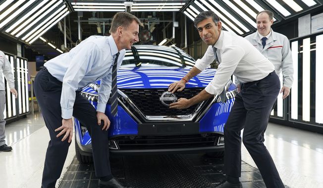 Britain&#x27;s Prime Minister Rishi Sunak, right and Chancellor of the Exchequer Jeremy Hunt attach a Nissan badge to a car as they visit the car manufacturer Nissan, in Sunderland, England, Friday, Nov. 24, 2023. Nissan will invest more than $1.3 billion to update its factory in northeast England to make electric versions of its two best-selling cars. It&#x27;s a boost for the British government as it tries to revive the country鈥檚 ailing economy. The Japanese automaker manufactures the gasoline-powered Qashqai and smaller Juke crossover vehicles at the factory in Sunderland, which employs 6,000 workers.  (Ian Forsyth/Pool Photo via AP)