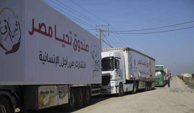 Trucks carrying humanitarian aid enter Gaza Strip from Egypt in Rafah as a temporary ceasefire went into effect Friday, Nov. 24, 2023. (AP Photo/Hatem Ali)