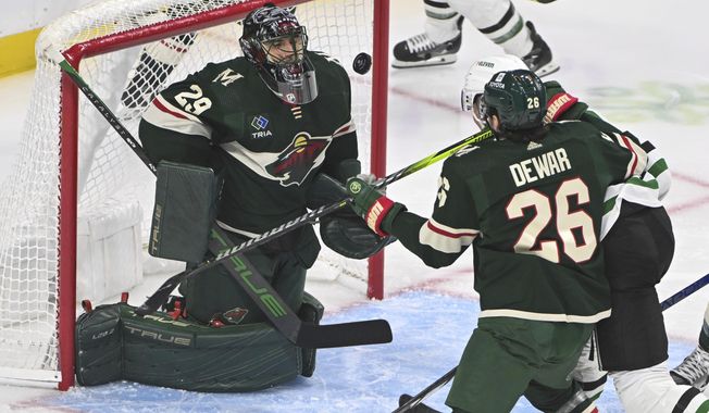 Minnesota Wild goalie Marc-Andre Fleury (29) blocks a shot by Dallas Stars center Radek Faksa, back right, as Wild center Connor Dewar tries to clear Faska from the goal during the first period of an NHL hockey game Sunday, Nov. 12, 2023, in St. Paul, Minn. (AP Photo/Craig Lassig)