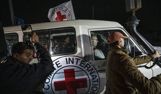 A Red Cross vehicle carrying Israeli hostages drives by at the Gaza Strip crossing into Egypt in Rafah on Saturday, Nov. 25, 2023. (AP Photo/Fatima Shbair)