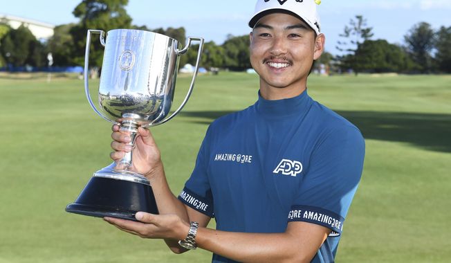 Australia&#x27;s Min Woo Lee holds his trophy after winning the Australian PGA Championship in Brisbane, Sunday, Nov. 26, 2023. (Jono Searle/AAP Image via AP)