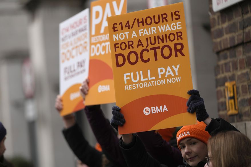 Junior doctors hold placards on a picket line outside St Mary's Hospital in London, Tuesday, March 14, 2023. Britain's government reached a deal with senior doctors in England that could potentially end a series of disruptive strikes, officials said Monday, Nov. 27, 2023. (AP Photo/Alastair Grant, File)