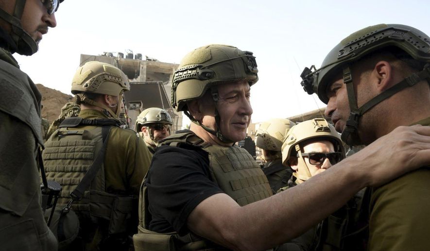 Israel&#x27;s Prime Minister Benjamin Netanyahu, centre, greets soldiers as he visits the Gaza Strip, where he received security briefings with commanders and soldiers and visited one of the tunnels that has been revealed, on Sunday Nov. 26, 2023. (Avi Ohayon/GPO/Handout via AP)
