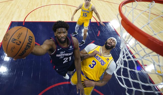 Philadelphia 76ers&#x27; Joel Embiid, left, goes up for a shot past Los Angeles Lakers&#x27; Anthony Davis during the first half of an NBA basketball game, Monday, Nov. 27, 2023, in Philadelphia. (AP Photo/Matt Slocum)