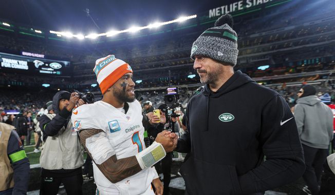 Miami Dolphins quarterback Tua Tagovailoa (1) interacts with New York Jets quarterback Aaron Rodgers (8) after the team&#x27;s win over the New York Jets during an NFL football game Friday, Nov. 24, 2023, in East Rutherford, N.J. (David Santiago/Miami Herald via AP) **FILE**