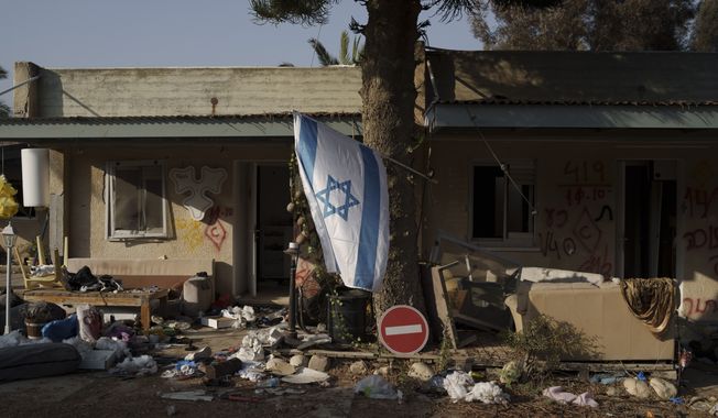 FILE - An Israeli flag hangs between destroyed houses in the kibbutz Kfar Azza, Israel, near the Gaza Strip, Monday, Nov. 13, 2023. It has become an Israeli mantra throughout the latest war in Gaza: Hamas is ISIS. Since the bloody Hamas attack on Oct. 7 that triggered the war, Israeli leaders and commanders have likened the Palestinian militant group to the Islamic State group. They point to Hamas鈥� brutal slaughter of hundreds of civilians and compare their Gaza war to the U.S.-led campaign to defeat IS in Iraq and Syria. (AP Photo/Leo Correa, File)