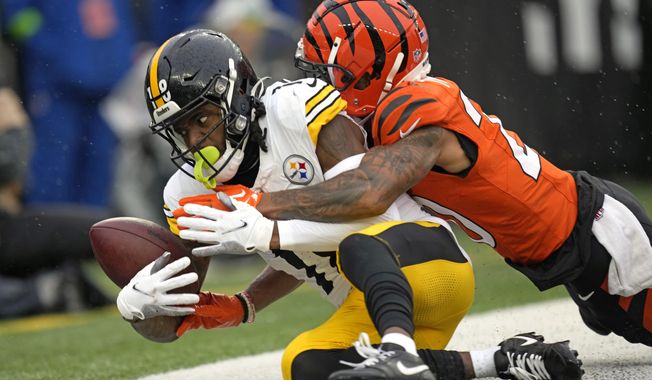 Pittsburgh Steelers wide receiver Diontae Johnson (18) can&#x27;t hang onto the ball as he falls out of the end zone with Cincinnati Bengals cornerback DJ Turner II (20) defending during the first half of an NFL football game in Cincinnati, Sunday, Nov. 26, 2023. There was no touchdown on the play. (AP Photo/Carolyn Kaster)