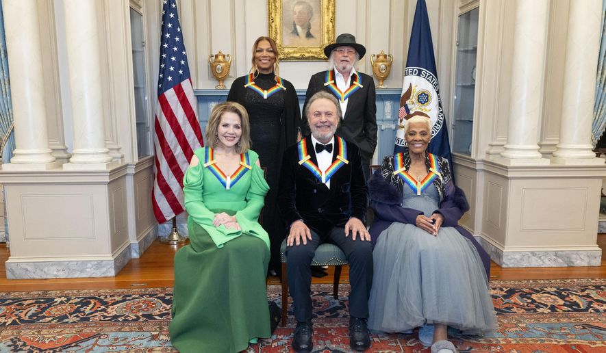 From left, 2023 Kennedy Center Honorees Renée Fleming, Queen Latifah, Billy Crystal, Barry Gibb and Dionne Warwick pose for a photo at the State Department following the Kennedy Center Honors gala dinner, Saturday, Dec. 2, 2023, in Washington. (AP Photo/Kevin Wolf)