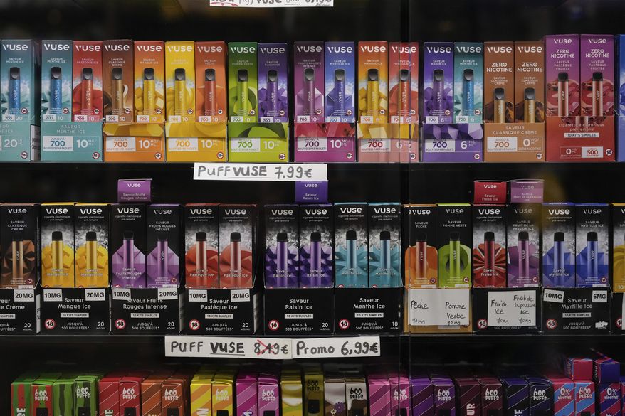 Disposable electronic flavored electronic cigarette devices are displayed for sale at a tobacco shop in Fontainebleau, south of Paris, France, Monday, Dec. 4, 2023. The National Assembly in France is preparing for a pivotal vote on Monday night on a bill to ban single-use, disposable electronic cigarettes, commonly known as "puffs." Attracting teenagers with their sweet flavors, these devices are facing scrutiny for their environmental implications. (AP Photo/Thibault Camus)