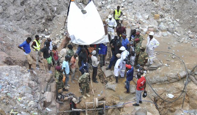 Government officials and miners are seen at the scene of the mine rescue mission on Sunday, Dec. 3, 2023 in Chingola, around 400 kilometres (248 miles) north of the capital Lusaka, Zambia. Seven miners were confirmed dead and more than 20 others were missing and presumed dead after heavy rains caused landslides that buried them inside tunnels they had been digging illegally at a copper mine in Zambia, police and local authorities said Saturday. (AP Photo)