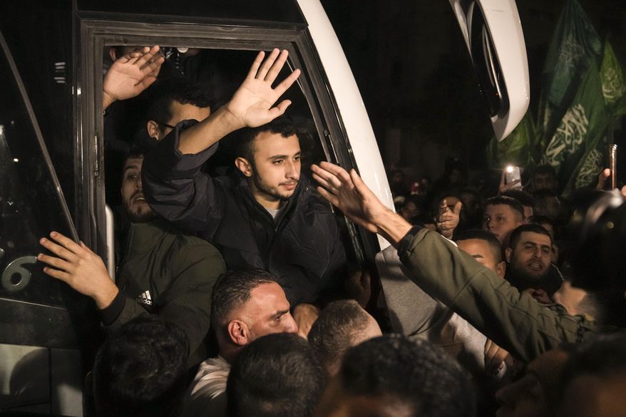 FILE - Men wave after being released from prison by Israel, Thursday, Nov. 30, 2023, in the West Bank town of Ramallah. (AP Photo/Nasser Nasser, File)