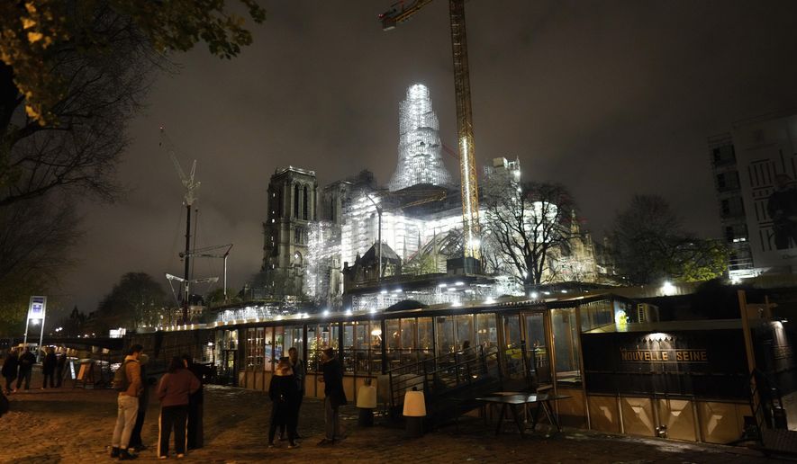 Notre-Dame de Paris cathedral is seen with its spire surrounded by scaffolding Tuesday, Dec. 5, 2023 in Paris. The restoration of Notre Dame hits a milestone Friday, Dec. 8, 2023: one year until the cathedral reopens its huge doors to the public. (AP Photo/Thibault Camus)