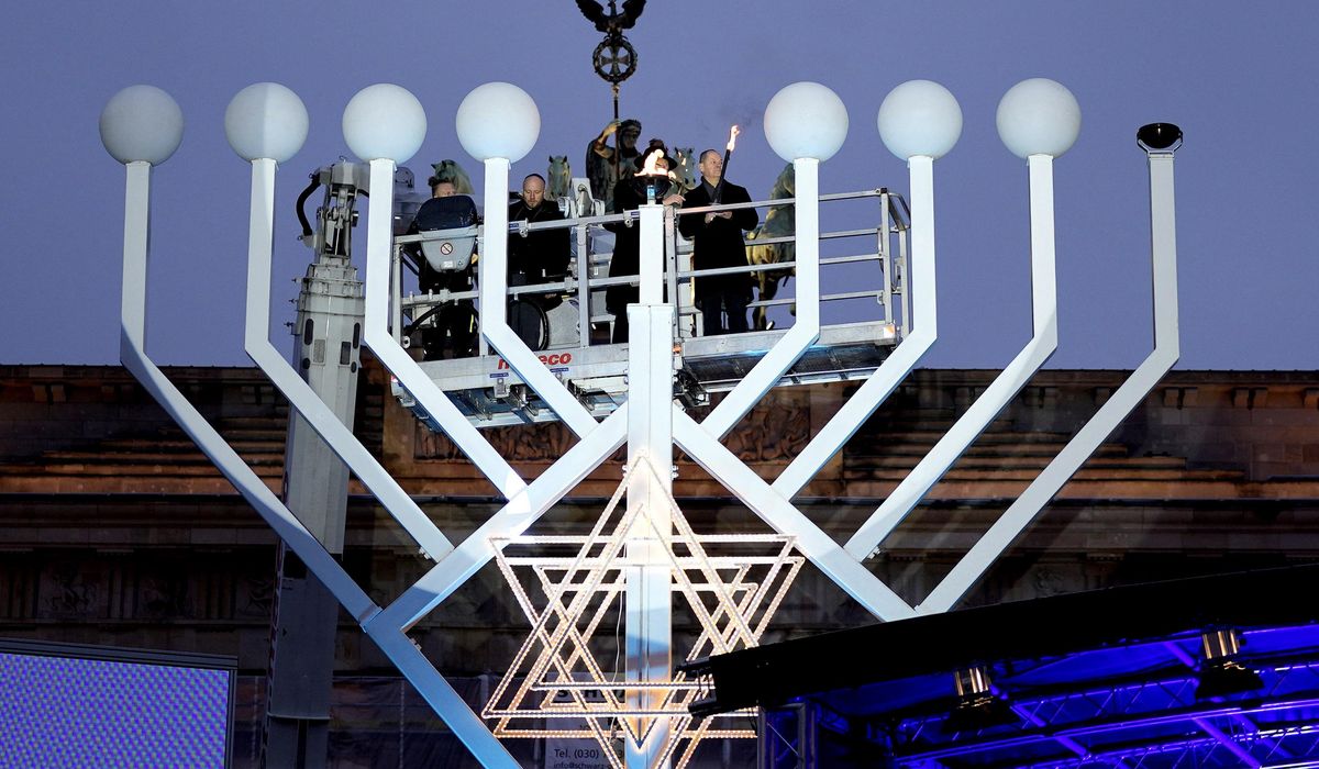 NextImg:Germany’s chancellor lights first Hanukkah candle on a huge menorah at Berlin’s Brandenburg Gate